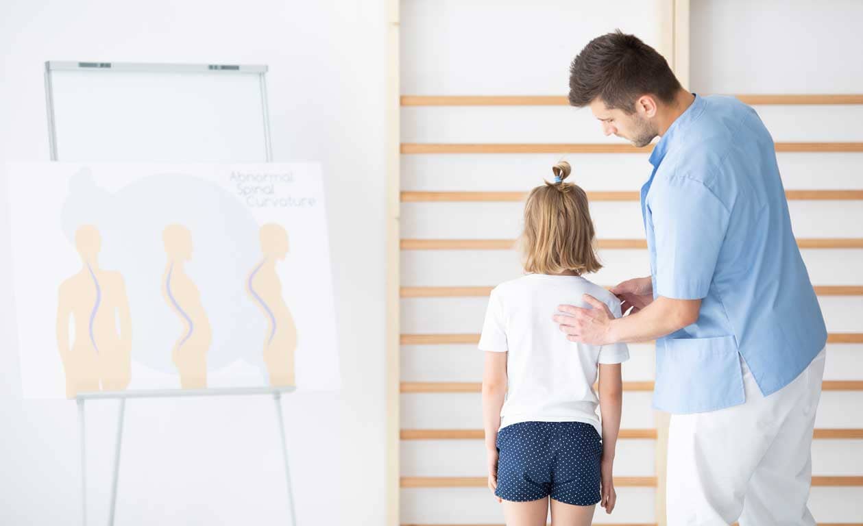 Young girl having a posture diagnosis by a chiropractor